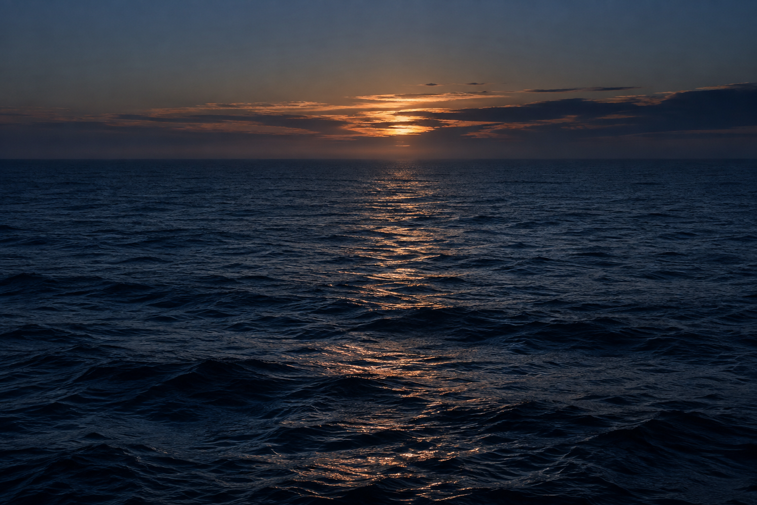 Luz dourada refletida sobre o mar azul ao entardecer