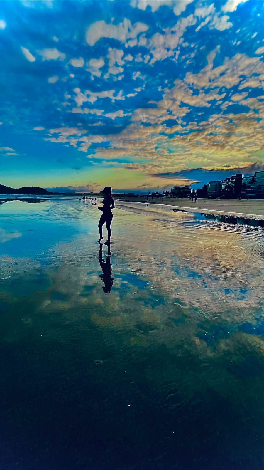 Um momento de presença à beira-mar, entre o céu e seu reflexo na água